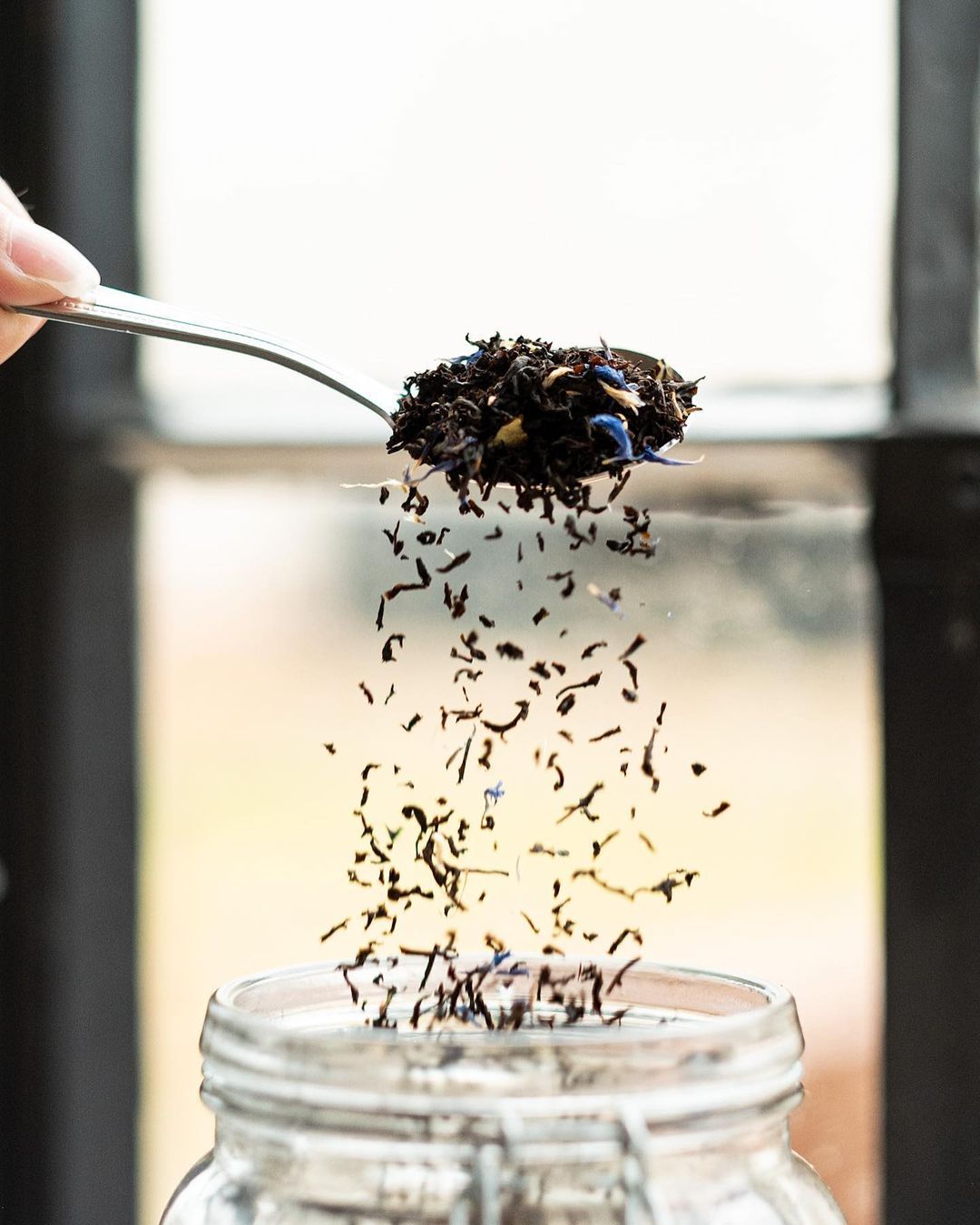 Loose leaf tea being poured into a jar